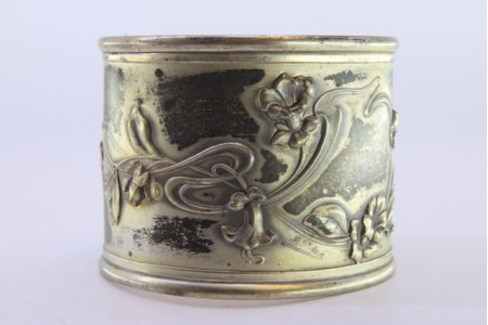 Argola de guardanapo em prata com motivos florais relevados e envolvendo cartela para monograma.